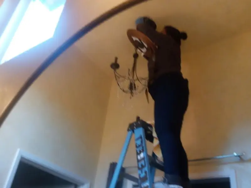 Electrician installing a chandelier in a Effingham residence